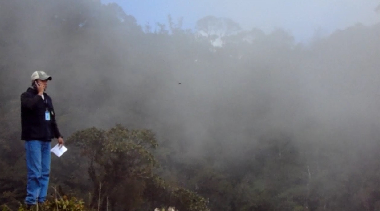 Health worker in Guatemala using mobile telephone in the misty hills.